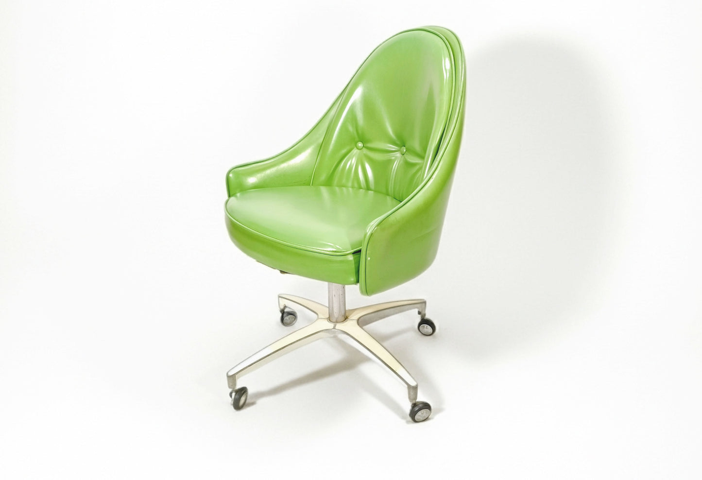 A mid-century modern office chair with a glossy lime green upholstered seat and curved backrest, mounted on a swivel base with casters.